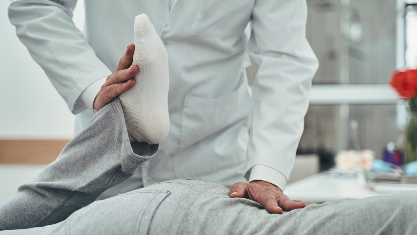 Doctor is performing passive modalities on patient laying face down.