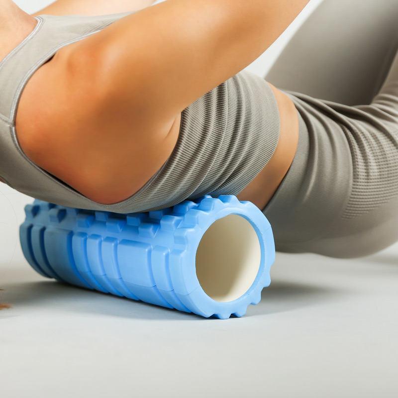 Person using a foam roller to sooth muscles after a workout.