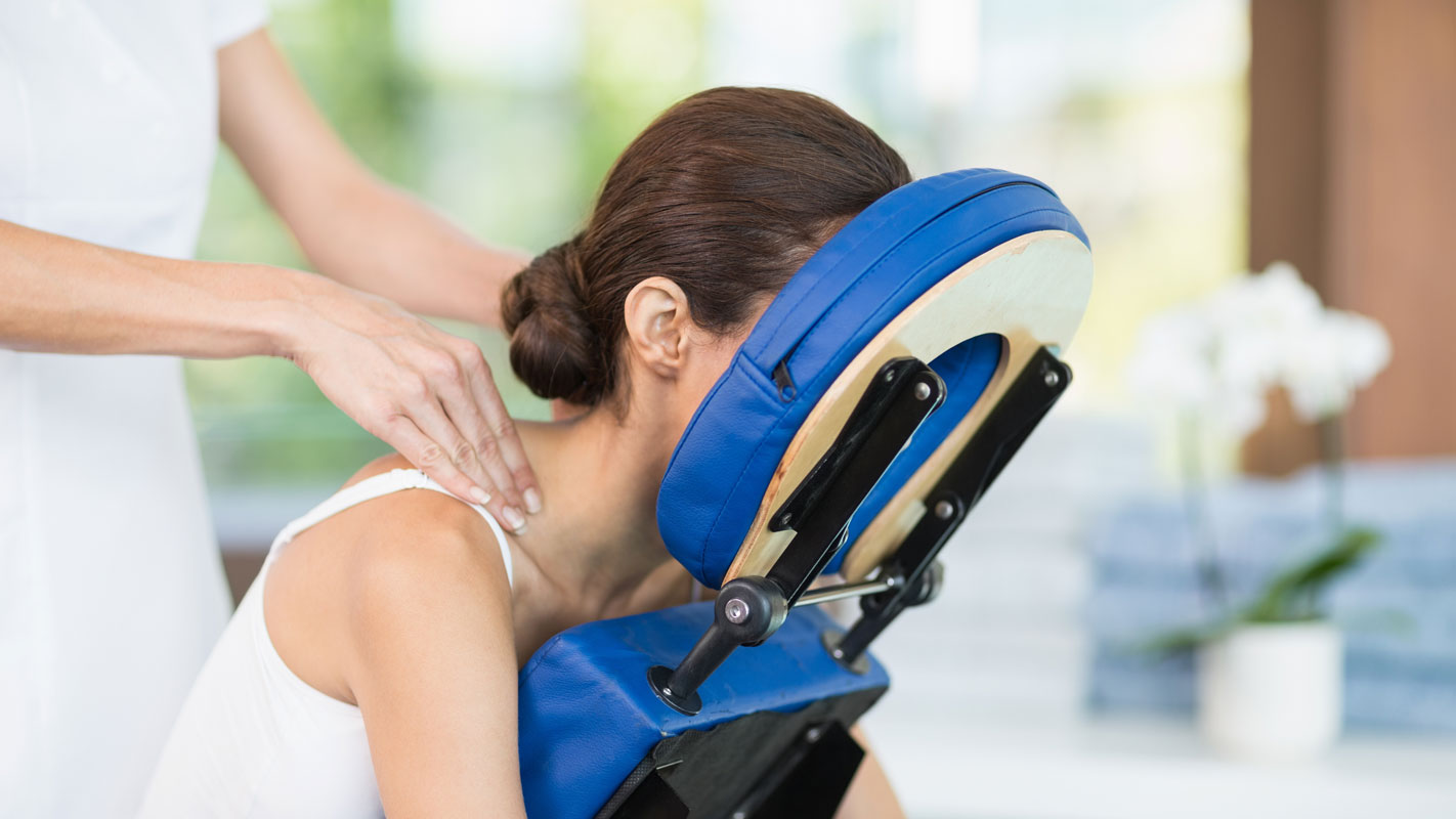 Woman has head stabilized during an adjustment to her neck.